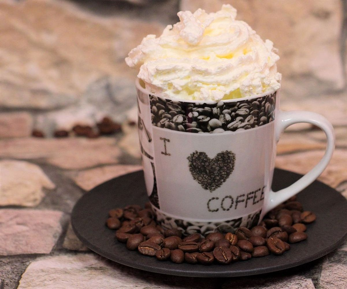 Hands scooping creamy gelato into a cup
